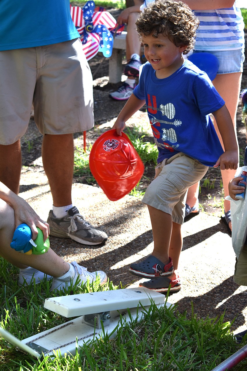 Corbin Merson plays a game after the Freedom Fest parade.