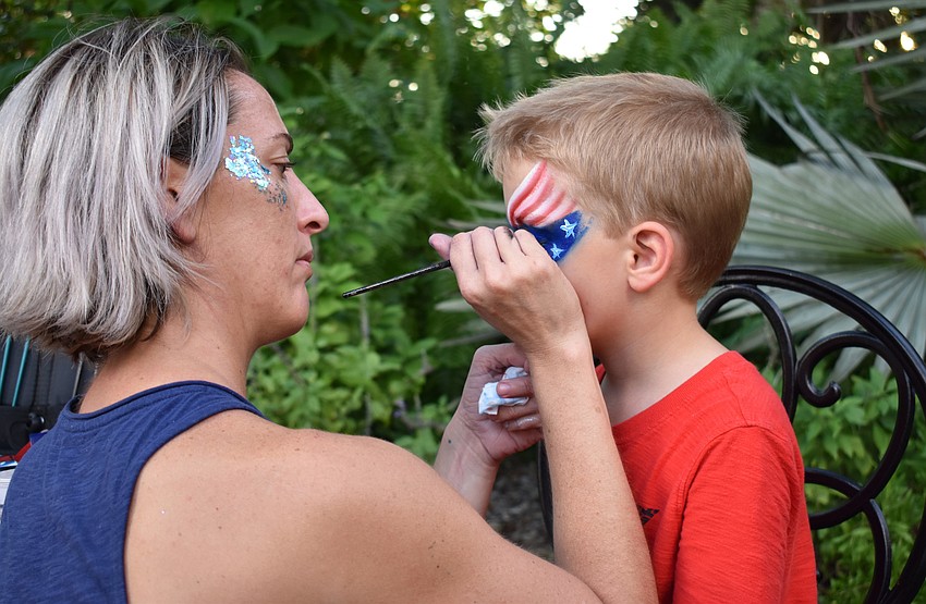 Ian Johnson gets an American flag painted on his face.