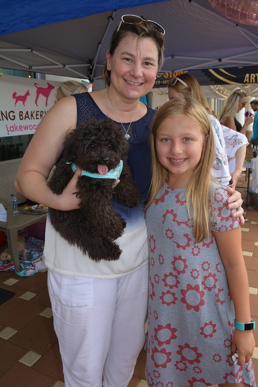 Wolf Gang Bakery owner Dottie DeCarlo gives a hug to some of her favorite patrons, Hazel and her owner Sadie Barbour, of University Place.