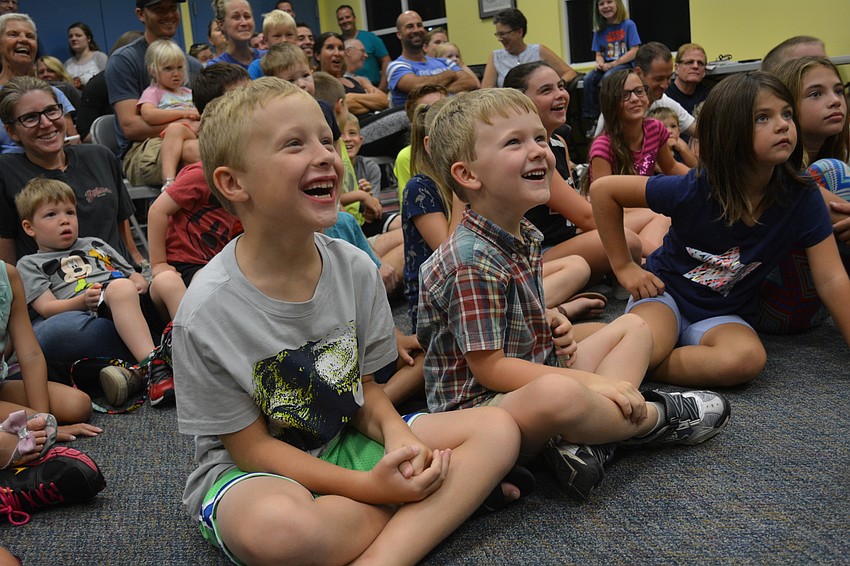 Sam Stephens, 8, and Ethan Parker, 5, laugh after a gopher tortoise goes to the bathroom while being displayed to the crowd.