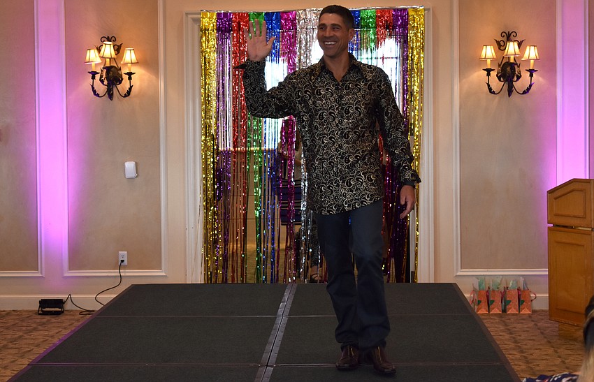 Adam Jaco waves to the crowd as he walks the runway.