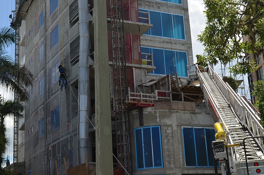 Emergency personnel lowered the man to the ground from above the tenth story of the building.