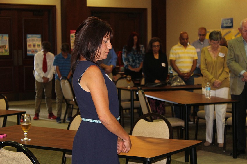 Sarasota's Tina Fasetti bows her head during a prayer for fallen soldiers.