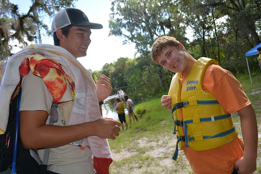 Braden River High senior and camp counselor Zach Marshall, 17, helps camper Brandon Todd apply sunscreen before a morning of canoeing.