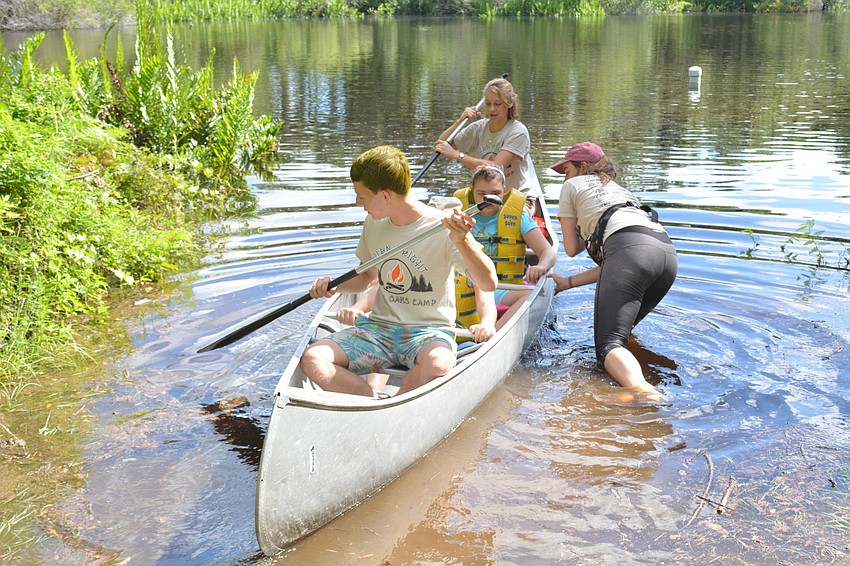 Counselor Lance Meckly, at the front of the canoe, will help steer his campers through the Manatee River.