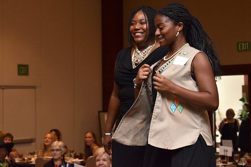 Natasha Burton, U.S. Air Force veteran, walks the runway with Girl Scout Kaila Stafford.