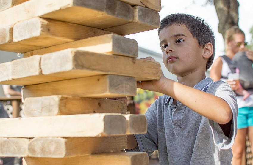 David Jacob plays with a giant game of Jenga during the JDub's one-year anniversary food truck rally.
