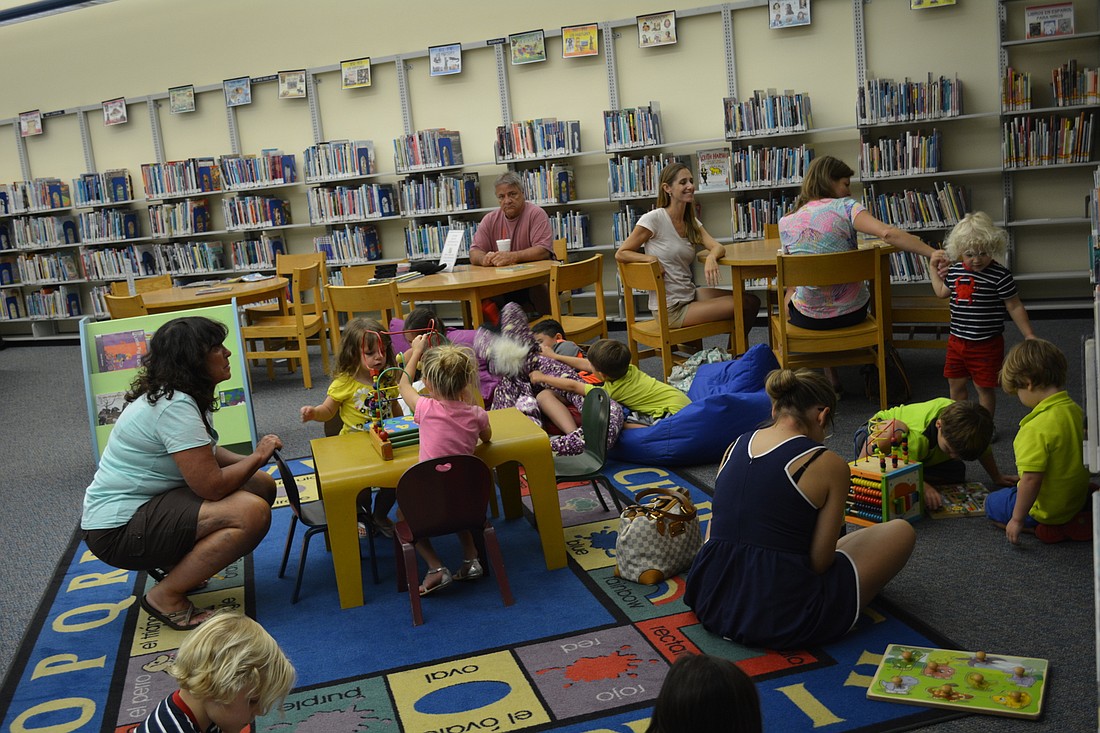 Children and families gather to peruse books after a science program July 20 at the Braden River Library. A upcoming library expansion will create more space for children and youth.