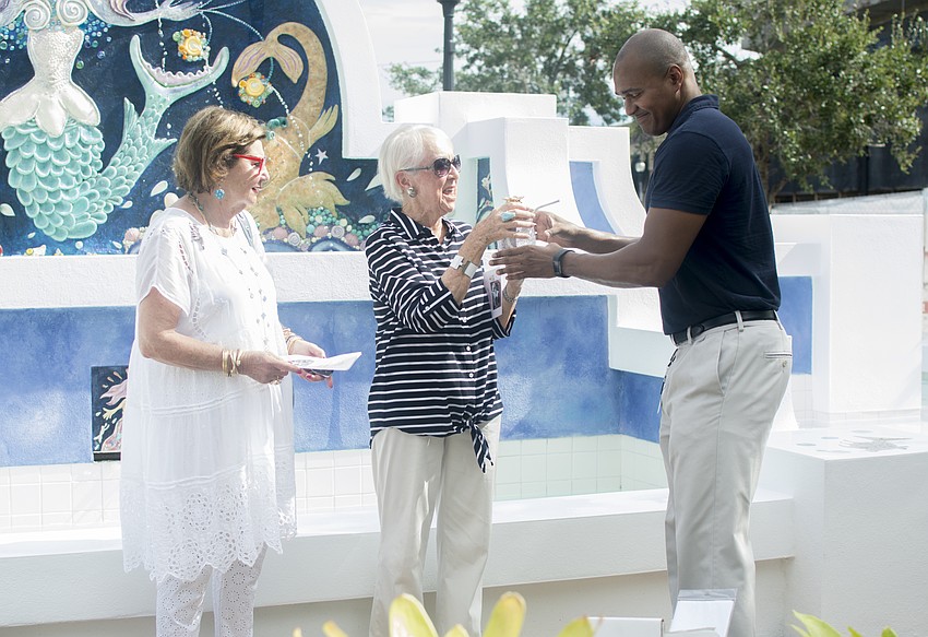 Parks and Recreation Director Jerry Fogle presents Barbara Campo and Renee Hamed with pineapple figurines for their efforts to restore the mermaid fountain.