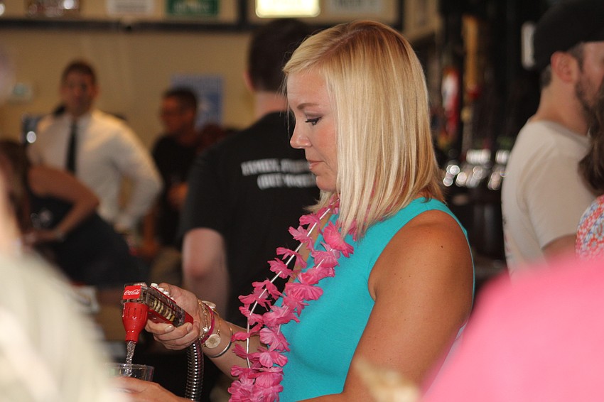Cheers for Charity member Amy Morris practices her bartending skills.