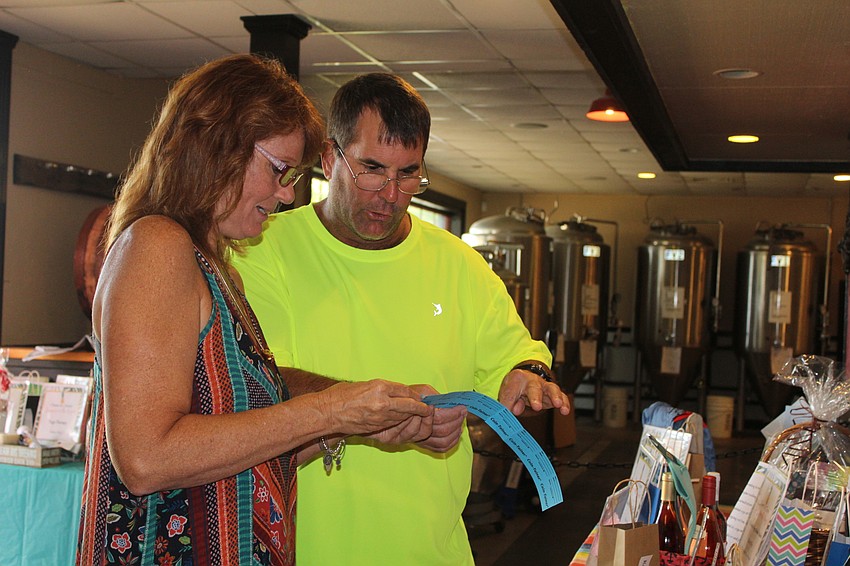 Bradenton's Tracey Vita and Steve Peebles check out raffle prizes.
