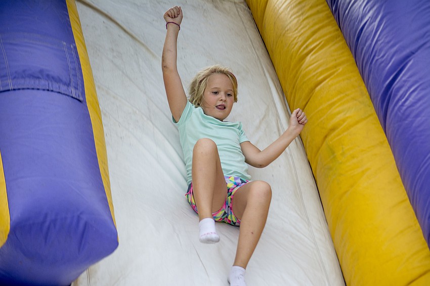 Norah McVicker slides down an inflatable slide during Alta Vista's Eagle Fest.