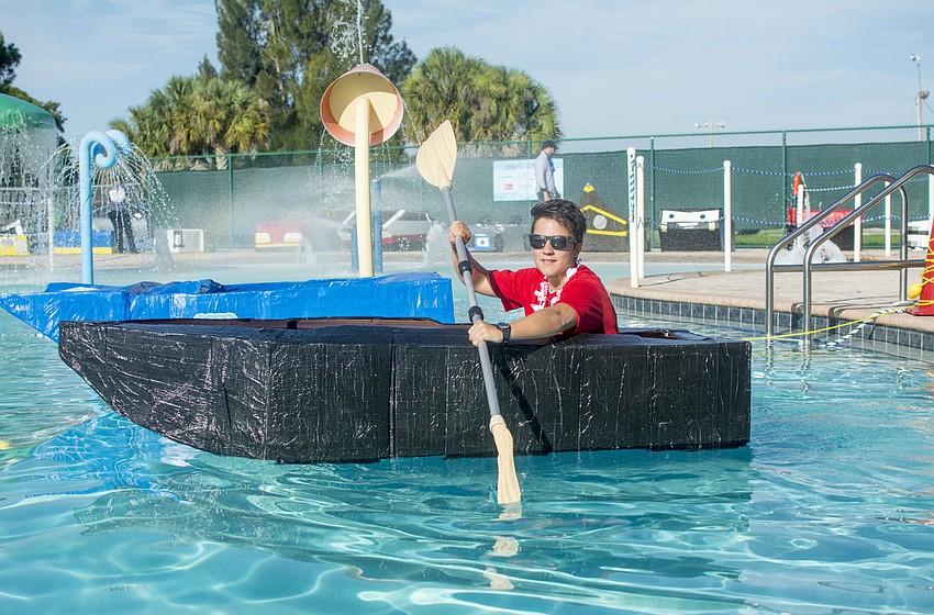 Life guard Vic Dina tests one of the cardboard and duct tape boats before the inaugural Rock the Boat Regatta that the Boys and Girls Club.