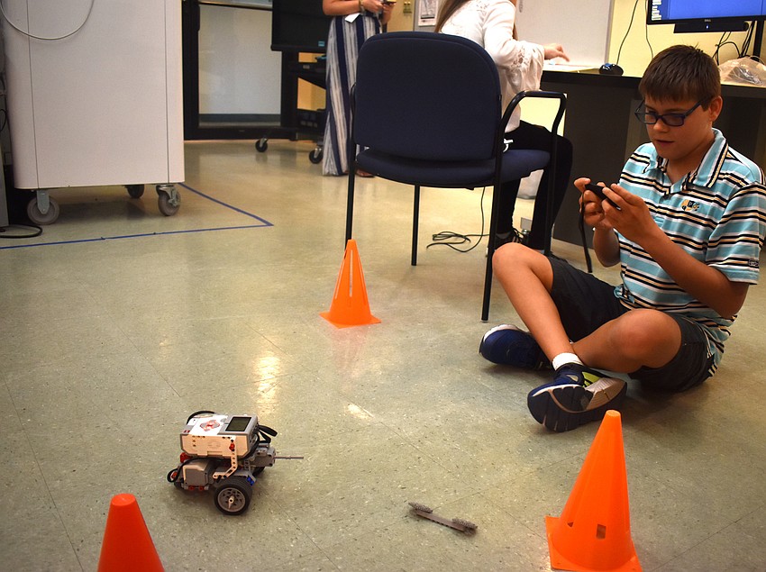 Michael Brookes races a Lego Mindstorm around a circle of cones.