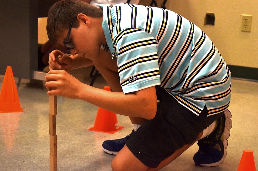 Michael Brookes stacks Jenga pieces together for his Lego Mindstorm to run into.