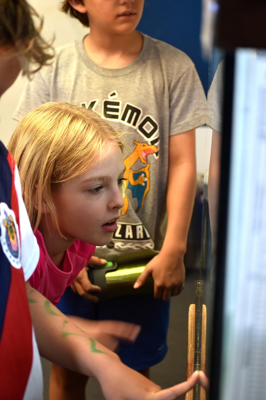Faith McCue watches one of the turtles swim around his tank.