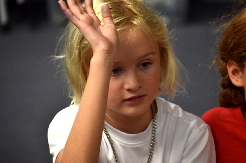 Marin Walters raises her hand to answer a sea turtle question.