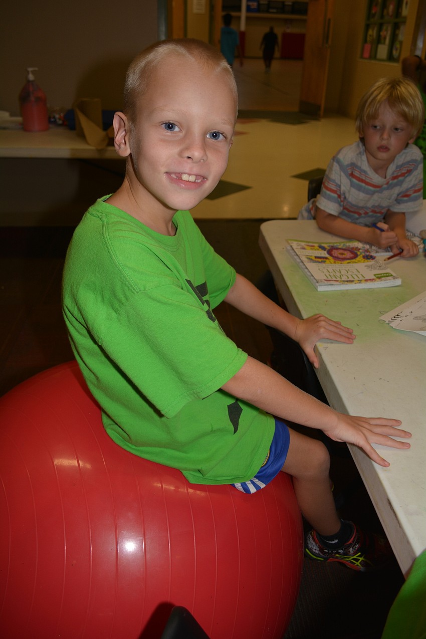 Egor Obukhov, 7, of McNeal Elementary, finds a unique seat from which to color.