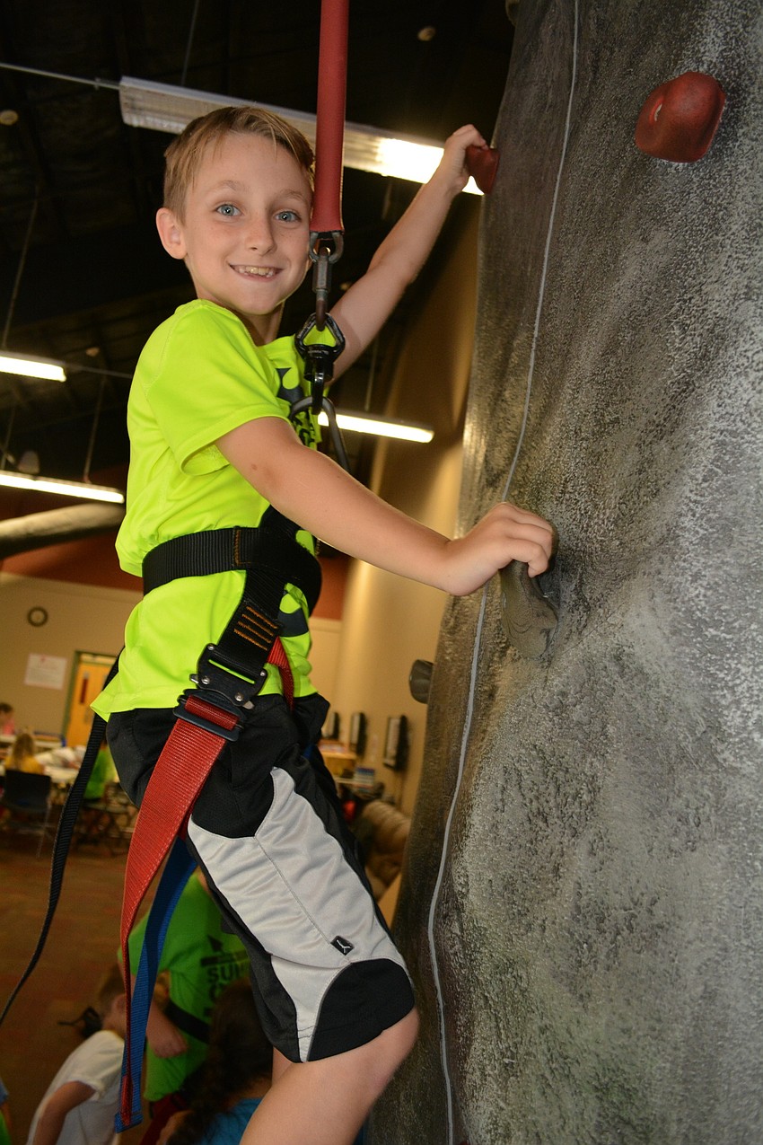 East County's Jason Bernius, 8, shows no fear climbing the rock wall.