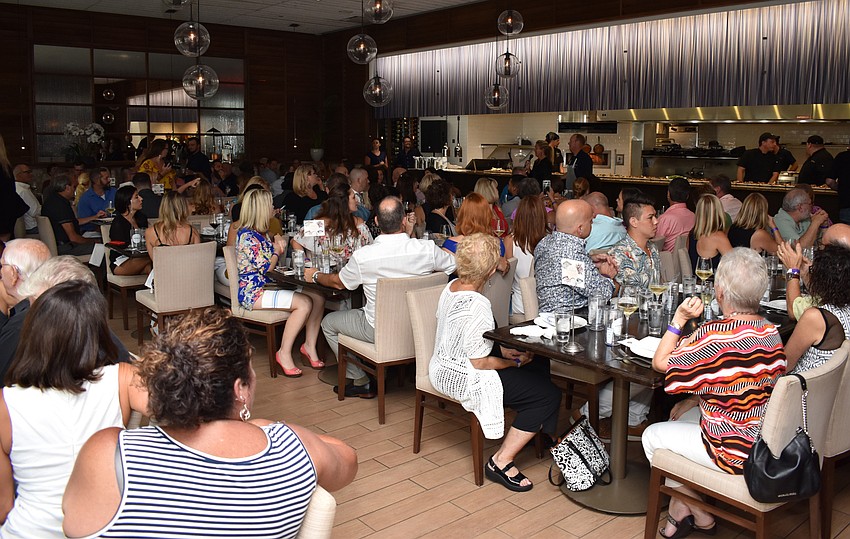 Guests listen to organizer Nikki Logan-Curran’s introduction at the Fourth Annual Sustainable Seafood Dinner on Aug. 6 at Louies Modern.