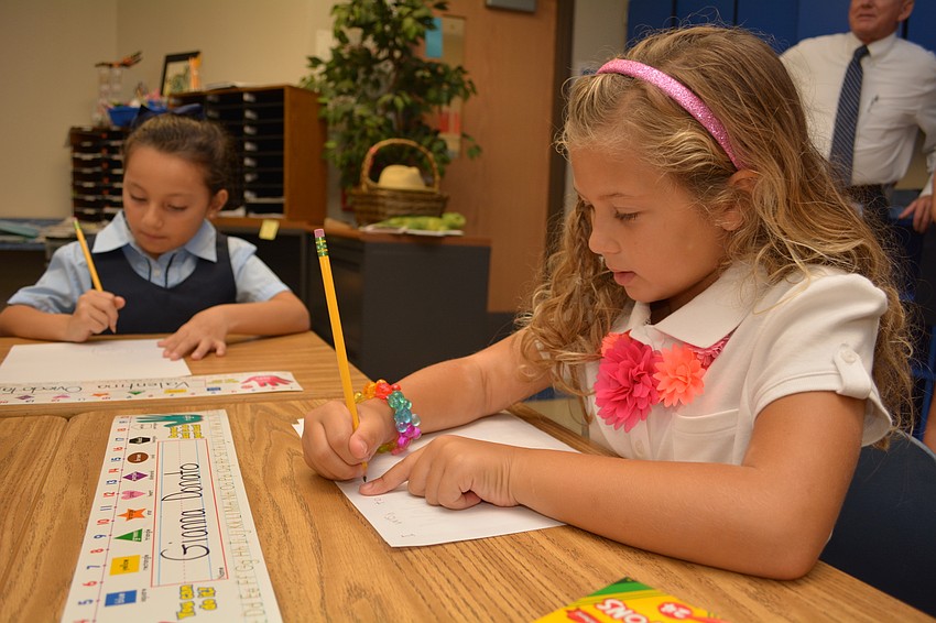 Gianna Donato, in white, gets busy in her new first-grade class.