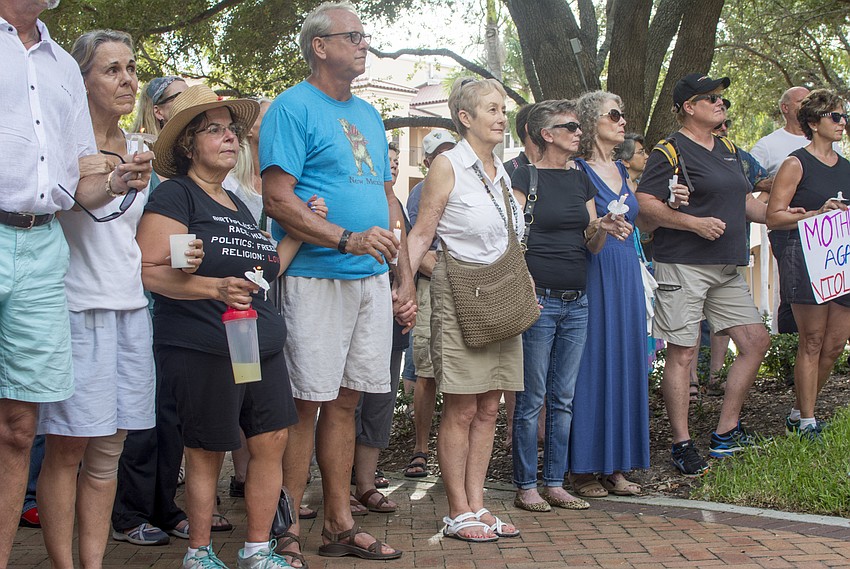 Demonstrators join hands during the Vigil Against Hate in Five Points Park on Aug. 13.