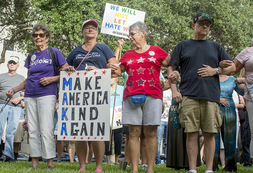 Demonstrators link arms during the Vigil Against Hate in Five Points Park on Aug. 13.