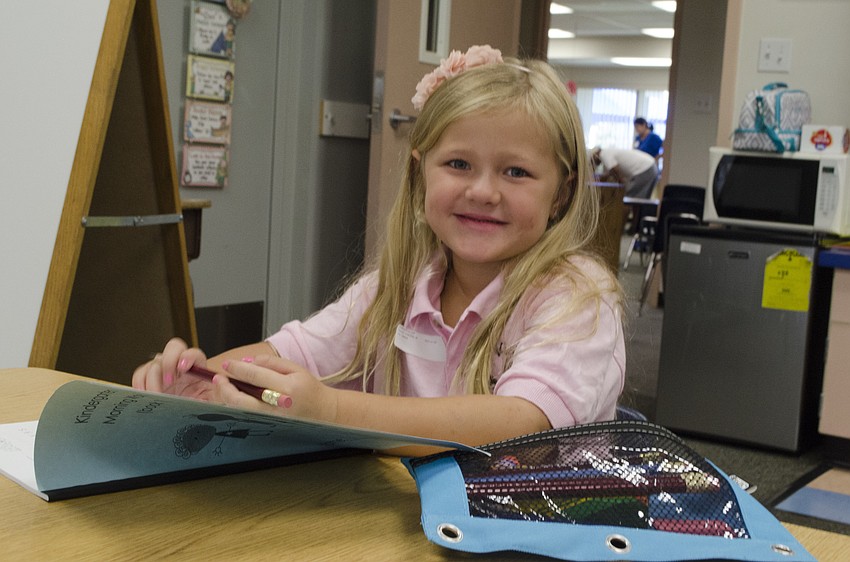 Kindergartener Cali Fuller checks out her workbook before class at Alta Vista Elementary on the first day of school.