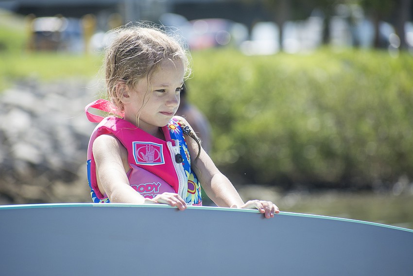 Susan Flanagan launches a paddle board into New Pass during the Engulfed Adventures Overlook Park cleanup.