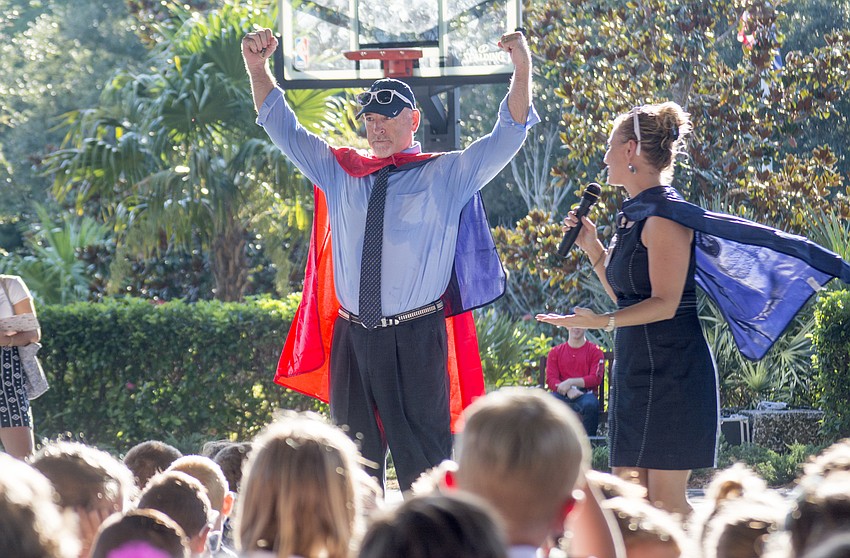 Facilities Director Dan Dennehy shows off his red cape after being named school superhero for his efforts in managing the solar project and the marine science lab.