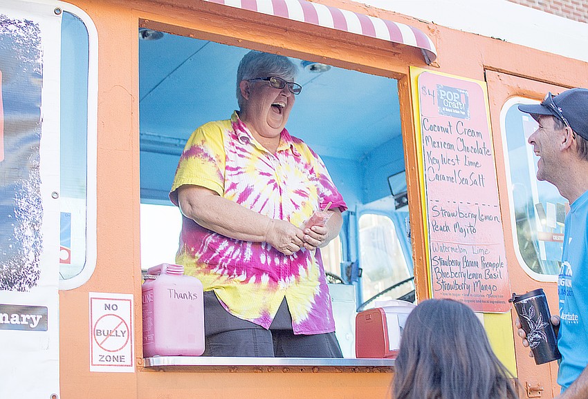Brenda Zook laughs with patrons during Sarasota Farmers Market tribute to Woodstock.