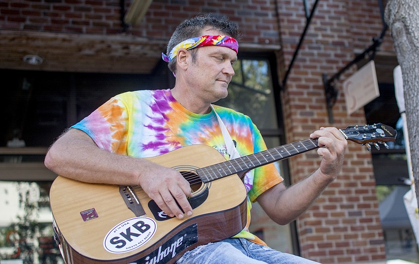 Karl Nelson plays guitar during Sarasota Farmers Market tribute to Woodstock.