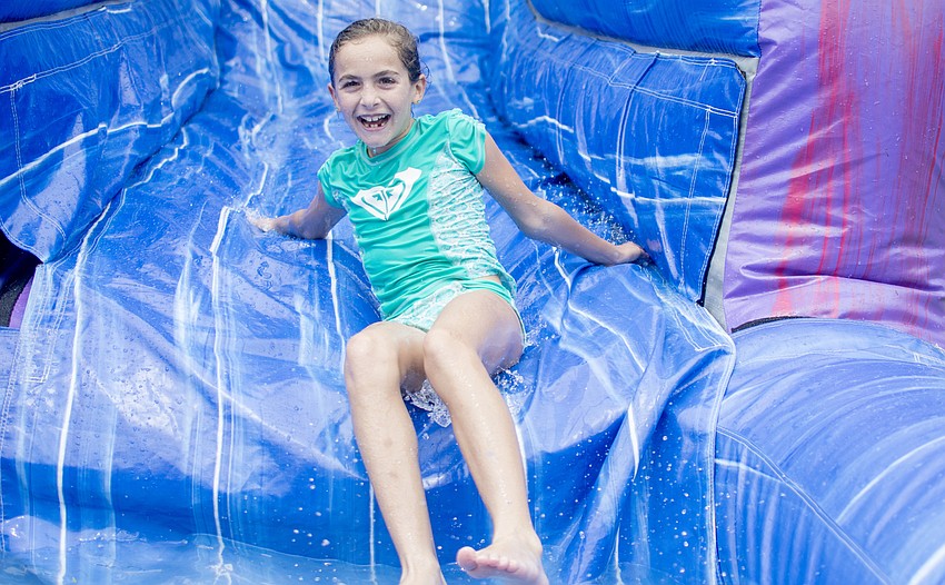Liza Collier slides down an inflatable water slide.