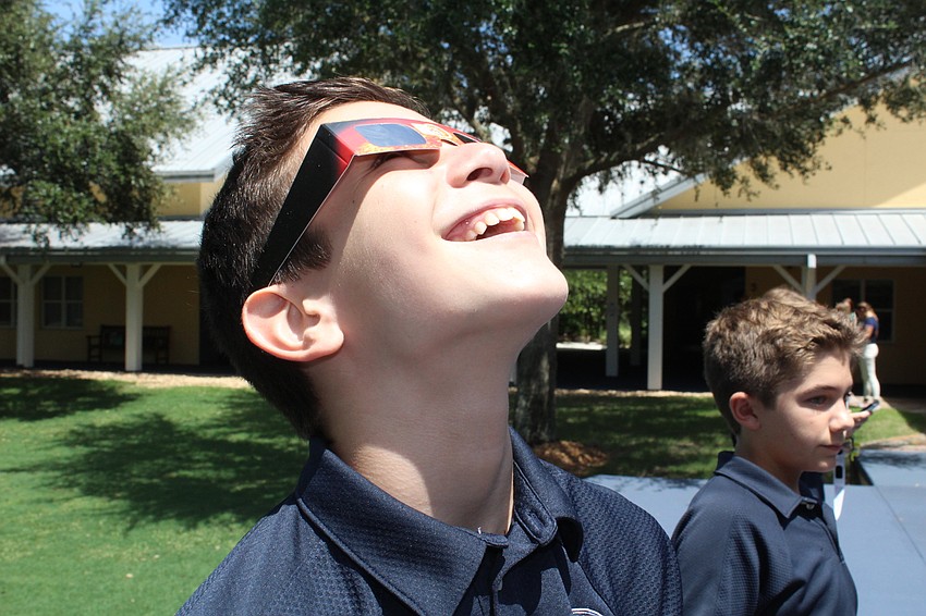 Out-of-Door Academy eighth-grader Anthony Gaukhman uses special glasses provided by the school to enjoy the solar eclipse.