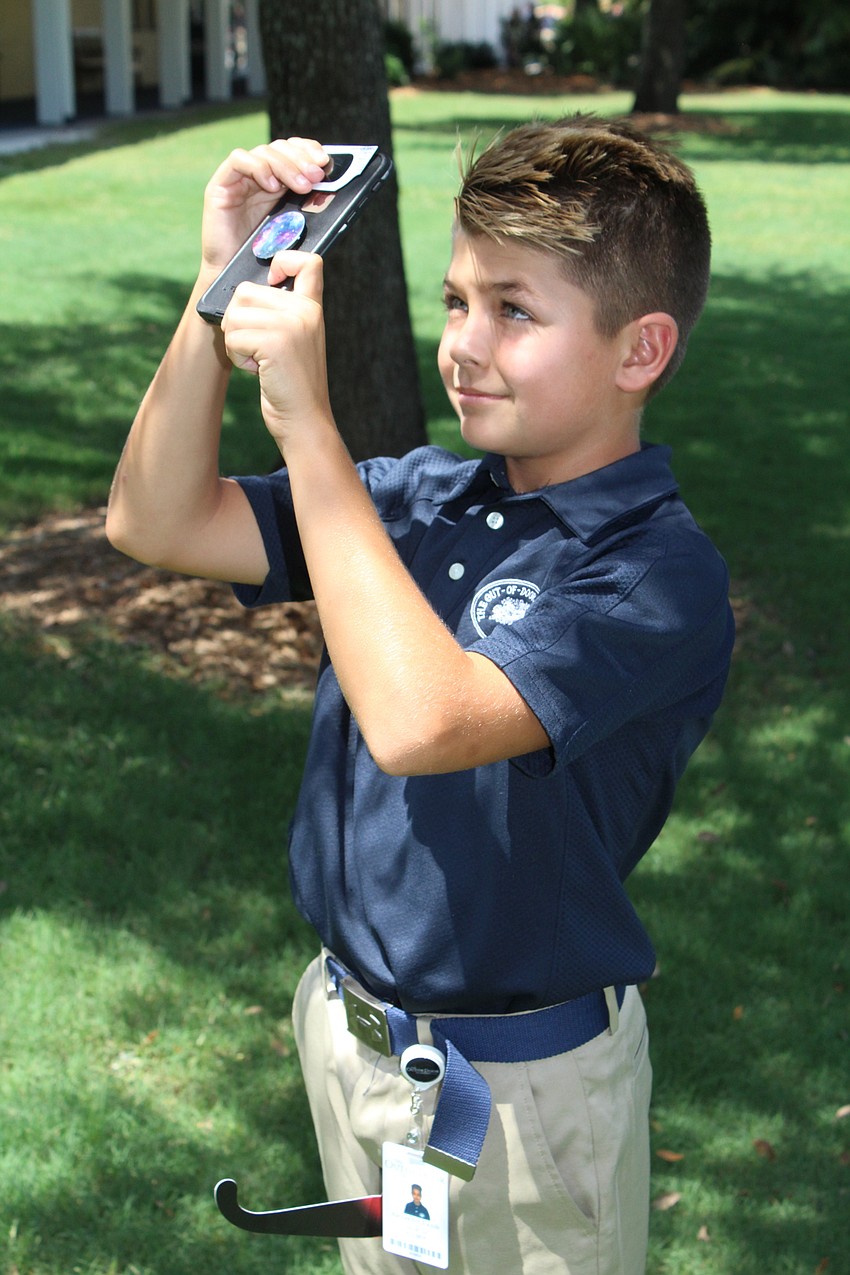 Out-of-Door Academy sixth-grader Alex Lamb tries out his cell phone filter.