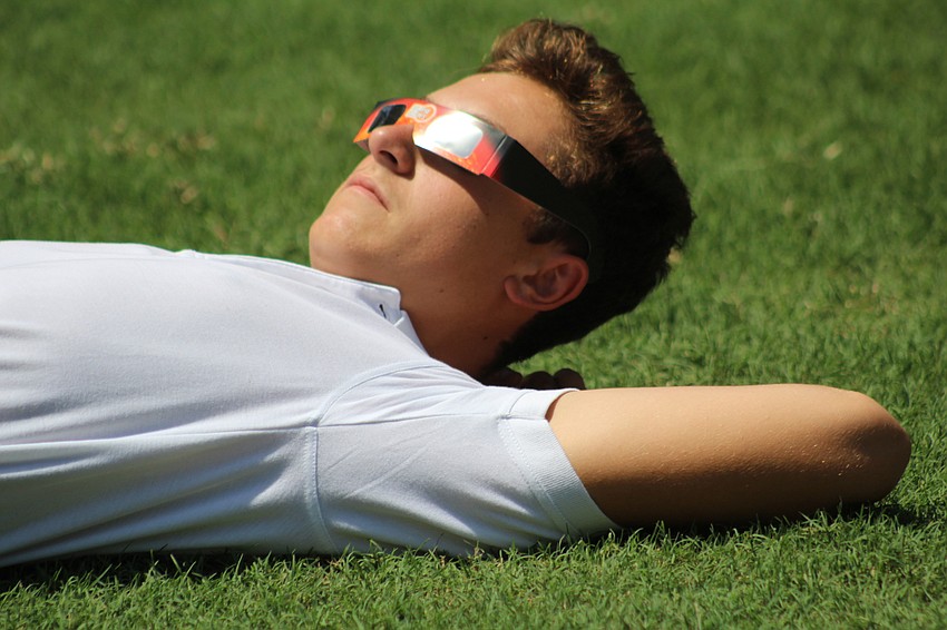 Out-of-Door Academy junior Xavier Koffman sits back and relaxes during the solar eclipse.