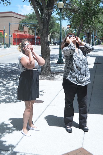 Jennifer Black (left) and Helen Harrington use special shaded sunglasses to observer the eclipse.