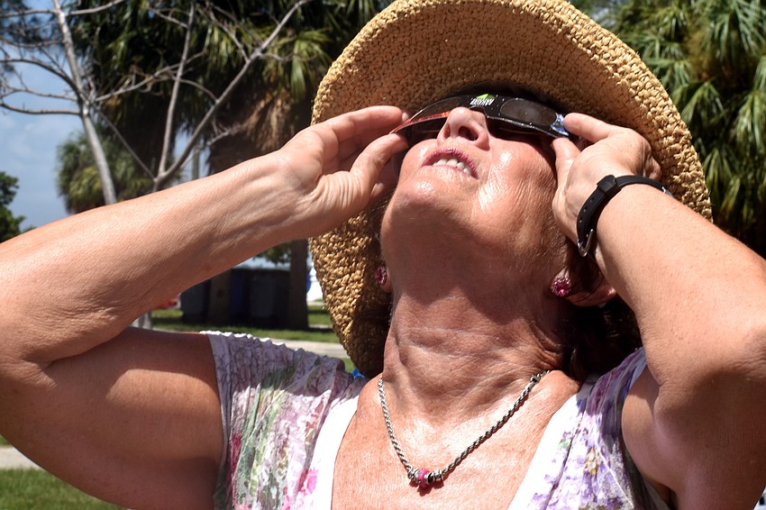 Christine Burns takes in the sight of the moon passing over the sun.