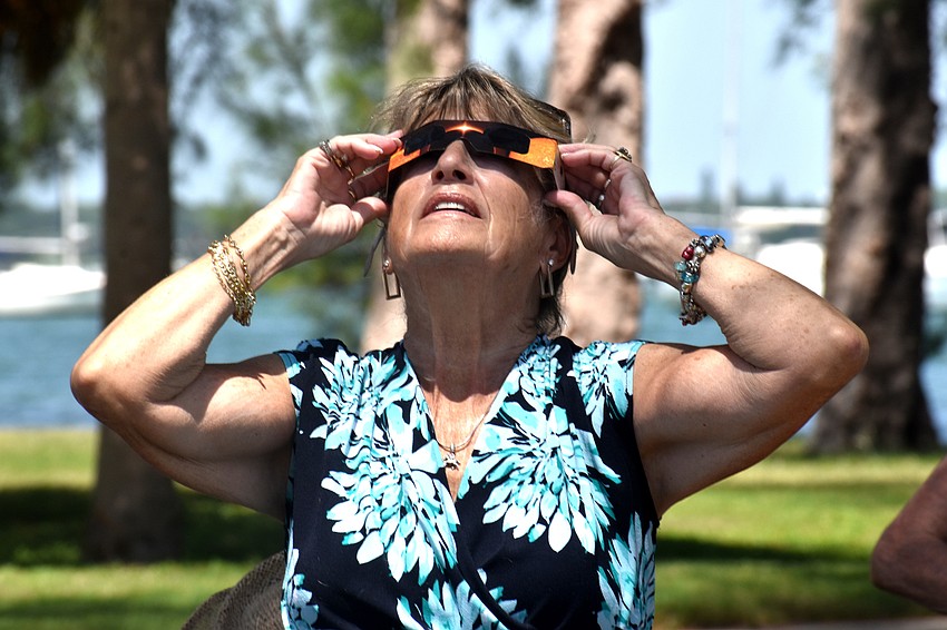 Joyce Hooey gazes as the moon nears the sun.
