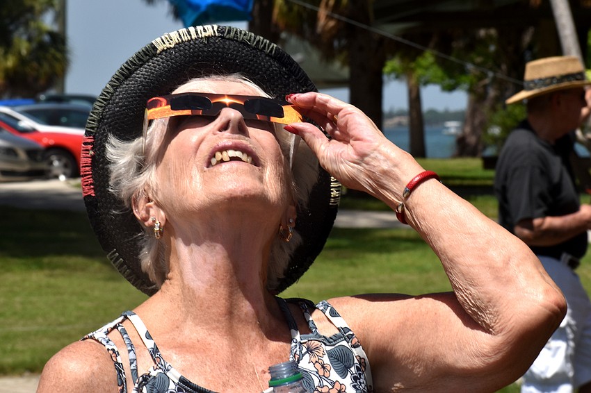 Lynne Woo smiles as she watches the solar eclipse.