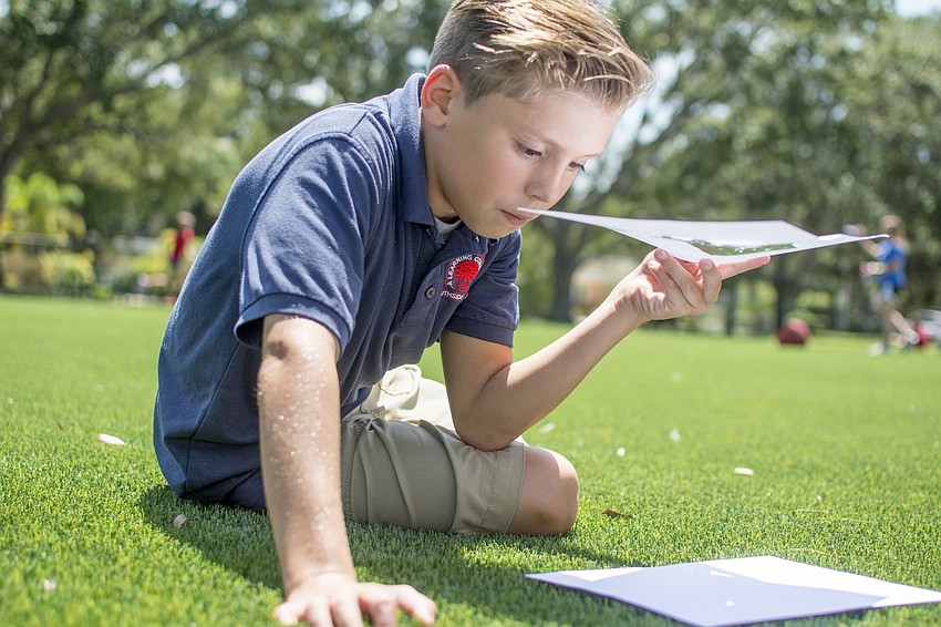 Van Ammond watches the eclipse through a pin hole viewing devise.