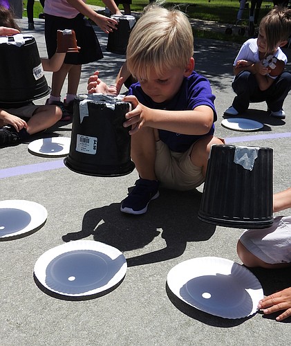 Anderson Miller uses a planting pot and paper plate to view the solar eclipse on Aug. 21 at  Hershorin Schiff Community Day School.