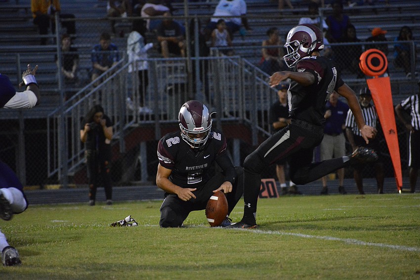 Mike Van Ness holds the ball for Dorian Hall on an extra point attempt.