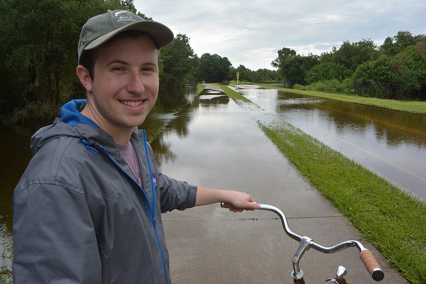 Quinn Pratt, visiting from San Diego, was contemplating whether he should drive into a flooded area of Hidden River Trail. Photo by Jay Heater.