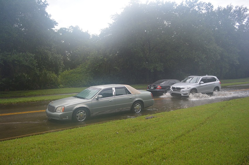A car makes its way through standing water on Tara Boulevard, past disabled vehicles that didn't make it through. Photo by Jay Heater.