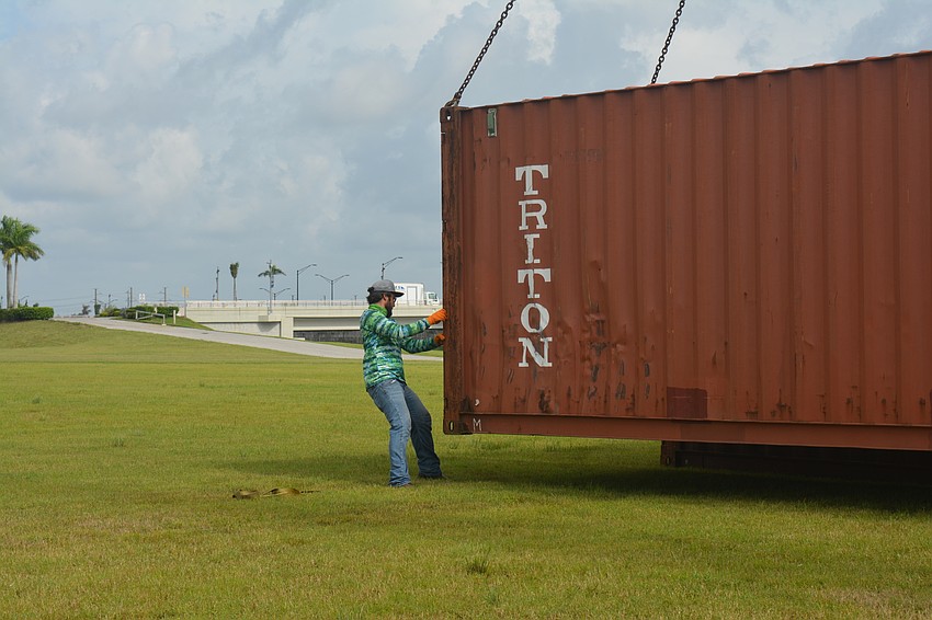 Skylar Bragg guides a shipping crate to the ground.
