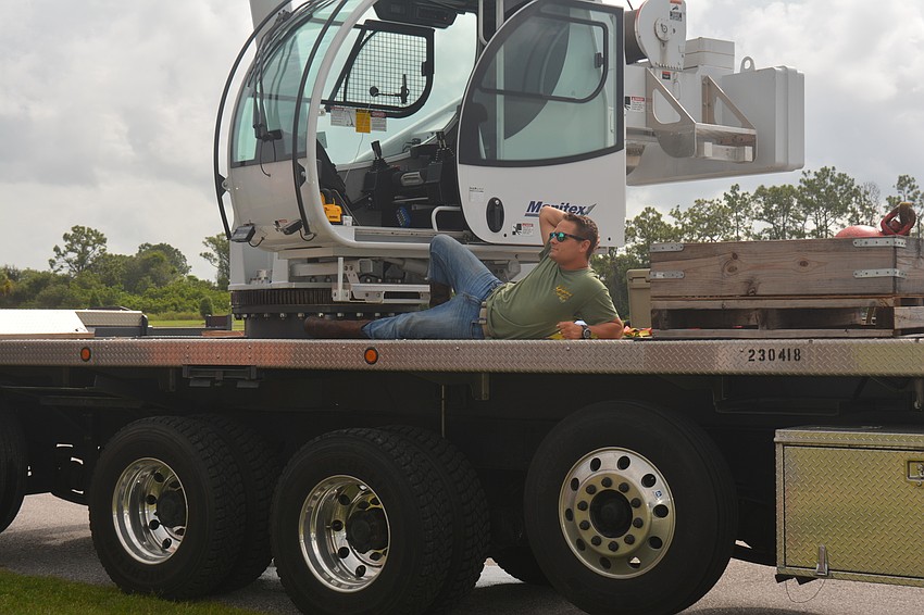 Justin Shrock takes a break from working the crane to watch the goings-on.