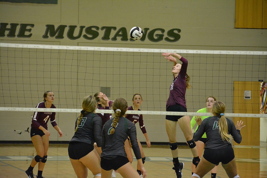 The Rams watch as Abby Quigley jumps for a spike attempt.
