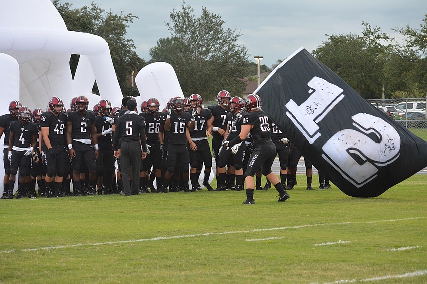 Chase Knopf (25) leads the team onto the field.