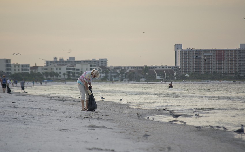 Lynn Jones picks up trash on Siesta Key Public Beach on Sept. 5.